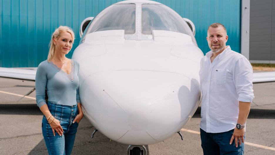 Die Geschäftsführerin von Silver Cloud Air und ein Mitarbeiter stehen gemeinsam vor dem Bug eines Businessjets.