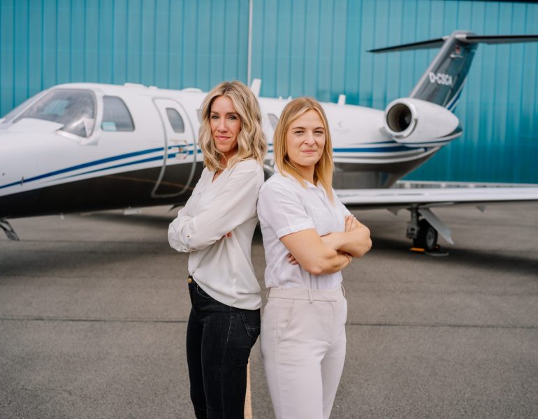 Teammitglieder von Silver Cloud Air vor einem Firmenflugzeug.